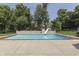 Relaxing in-ground pool with a slide, ladder and concrete patio surrounded by greenery at 3795 Claybrook Ct, Bargersville, IN 46106