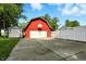 Exterior view of a large red barn with a white garage door and a long concrete driveway at 3905 E 550 S, Lebanon, IN 46052