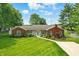 Charming brick and vinyl home with lush front yard, colorful flowers and paved driveway at 3905 E 550 S, Lebanon, IN 46052