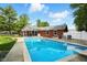 A stunning in-ground pool is surrounded by a brick home and a well manicured lawn at 3905 E 550 S, Lebanon, IN 46052