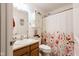 Bright bathroom with vanity, floral shower curtain, and storage cabinet above toilet at 4233 Pearson Dr, Westfield, IN 46062