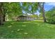 Large, grassy backyard featuring mature trees and the home's exterior at 4350 Sylvan Rd, Indianapolis, IN 46228