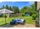 Backyard featuring a patio seating area with a sofa, umbrella, playset and green lawn at 4350 Sylvan Rd, Indianapolis, IN 46228