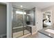 This modern shower features gray tile, a bench, and glass doors, next to the main bedroom at 4358 Persian St, Greenwood, IN 46143