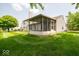 Lush green backyard featuring a screened-in porch and mature trees for added privacy at 4420 Victory Blvd, Indianapolis, IN 46203
