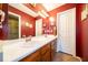 Bathroom with a double sink vanity, large mirror, and cherry wood cabinets at 4420 Victory Blvd, Indianapolis, IN 46203