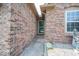 Close-up of home's brick entrance, featuring the front door and sidelight window at 4420 Victory Blvd, Indianapolis, IN 46203