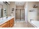 Bathroom with double sink vanity, tile floor, separate tub and shower with glass doors at 47 Torrey Pine Dr, Brownsburg, IN 46112