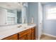 Bathroom with blue walls, white fixtures, tiled floor and wood vanity at 47 Torrey Pine Dr, Brownsburg, IN 46112