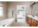 Bright bathroom with double sink vanity, soaking tub, tile floors and view into the bedroom at 47 Torrey Pine Dr, Brownsburg, IN 46112