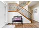 Inviting foyer featuring hardwood floors, staircase with decorative railings, and a stylish entryway bench at 47 Torrey Pine Dr, Brownsburg, IN 46112