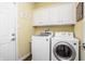 Dedicated laundry room includes washer, dryer, cabinet storage, and painted yellow walls at 47 Torrey Pine Dr, Brownsburg, IN 46112