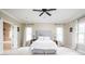 Spacious main bedroom with white bedding, ceiling fan and lots of light from the windows at 47 Torrey Pine Dr, Brownsburg, IN 46112
