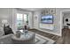 Cozy living room featuring a window and a wall-mounted TV with storage below at 5084 Foxley Park Ln, Avon, IN 46123