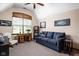 Bedroom featuring a dark blue couch, work desk, large window with wooden trim and a ceiling fan at 5194 Orahood Ct, Plainfield, IN 46168