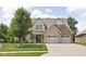 Charming two-story home featuring a manicured lawn, mature tree, and a blend of brick and stone accents at 5194 Orahood Ct, Plainfield, IN 46168