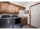 Laundry room featuring wood cabinetry, modern washer and dryer, and tiled flooring at 5194 Orahood Ct, Plainfield, IN 46168