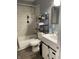 Well-maintained bathroom featuring updated fixtures, a shower-tub combo, and storage shelves for toiletries and towels at 52 S 16Th Ave, Beech Grove, IN 46107