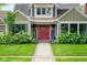 Charming home featuring a red front door, beautiful landscaping and lush green lawn at 5425 N Delaware St, Indianapolis, IN 46220