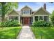 Charming home featuring a red front door, beautiful landscaping and lush green lawn at 5425 N Delaware St, Indianapolis, IN 46220