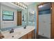 A well-lit bathroom with a double sink vanity, large mirror, and open shower space at 5847 Democracy Dr, Indianapolis, IN 46254