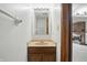 Compact bathroom featuring a light wood vanity and a view to the living room with fireplace at 5847 Democracy Dr, Indianapolis, IN 46254