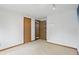 A neutrally decorated bedroom with two doors, neutral carpet, a shelf and white walls at 5847 Democracy Dr, Indianapolis, IN 46254
