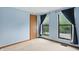 A light and airy bedroom with two windows dressed with blue curtains, neutral carpet and a door at 5847 Democracy Dr, Indianapolis, IN 46254