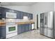 Modern kitchen with stainless steel refrigerator, gray cabinets and white appliances at 5847 Democracy Dr, Indianapolis, IN 46254