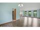 Open living room with wood floors, multiple windows, and a view of the stairs and kitchen at 5847 Democracy Dr, Indianapolis, IN 46254