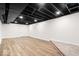 Unfinished basement shows open ceiling with room for storage and updated floors at 6337 Cardinal Ln, Indianapolis, IN 46220