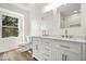 Bright bathroom featuring double vanity with carrara marble, modern fixtures, and natural light at 6337 Cardinal Ln, Indianapolis, IN 46220