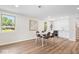 Open dining area with bar, modern table, and seating, illuminated by bright windows at 6337 Cardinal Ln, Indianapolis, IN 46220
