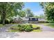 Charming home featuring a circular driveway, lush landscaping, and mature trees at 6337 Cardinal Ln, Indianapolis, IN 46220