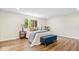 Cozy main bedroom with a blue bench, hardwood floors, and two bedside tables at 6337 Cardinal Ln, Indianapolis, IN 46220