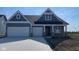 Charming home featuring a two-car garage and stylish exterior with a combination of brick and blue siding accents at 6367 Stone Side Dr, Plainfield, IN 46168