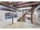 Unfinished basement with open ceiling, concrete floor, and staircase to the main level at 6616 S Cross St, Pendleton, IN 46064