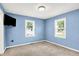 Blue bedroom with two windows, carpet, and a TV mounted on the wall at 6616 S Cross St, Pendleton, IN 46064