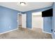 Spacious bedroom with a blue accent wall, plush carpet, and ample closet space at 6616 S Cross St, Pendleton, IN 46064