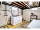 Basement laundry area features a washer and dryer, utility sink, and shelving for storage at 6616 S Cross St, Pendleton, IN 46064