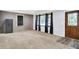 Cozy living room with modern gray walls, gray carpet, an ornate door, and abundant natural light at 6616 S Cross St, Pendleton, IN 46064