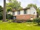 Spacious backyard featuring a lovely lawn, mature trees, and beautiful stone details around the property at 7038 E 65Th St, Indianapolis, IN 46256