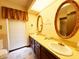 Bright bathroom with double sinks, large mirrors, and stylish gold fixtures, creating a spa-like experience at 7038 E 65Th St, Indianapolis, IN 46256
