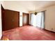 Bright bedroom featuring red carpet, large windows, and two closet doors at 7038 E 65Th St, Indianapolis, IN 46256