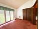 Bedroom featuring red carpet, closet door, and view to outside at 7038 E 65Th St, Indianapolis, IN 46256
