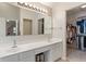 Bathroom with double sinks, lots of lighting, a vanity, and walk-in closet at 7356 Woodington Pl, Indianapolis, IN 46259