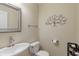 Half bathroom with a sink, toilet, decorative tree art, and a chrome faucet at 7356 Woodington Pl, Indianapolis, IN 46259