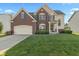 Charming two-story home with brick and siding, featuring a well-manicured lawn and attached two-car garage at 7356 Woodington Pl, Indianapolis, IN 46259