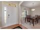 Inviting foyer with a view of the dining room features a white door with sidelight and wood flooring at 7356 Woodington Pl, Indianapolis, IN 46259