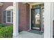 Inviting front door with brick facade, white columns, and clear address numbers at 7356 Woodington Pl, Indianapolis, IN 46259